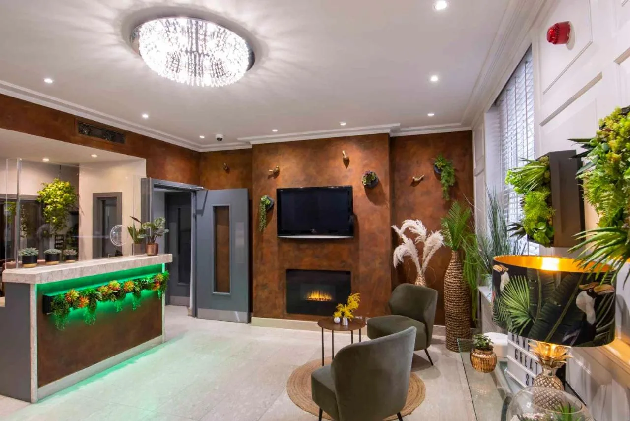 a living room with a fireplace and a tv at Howard Winchester Hotel in London