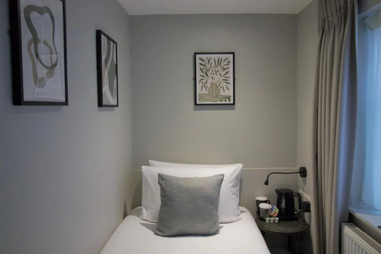 a hotel room with a bed with a pillow on it at Howard Winchester Hotel in London