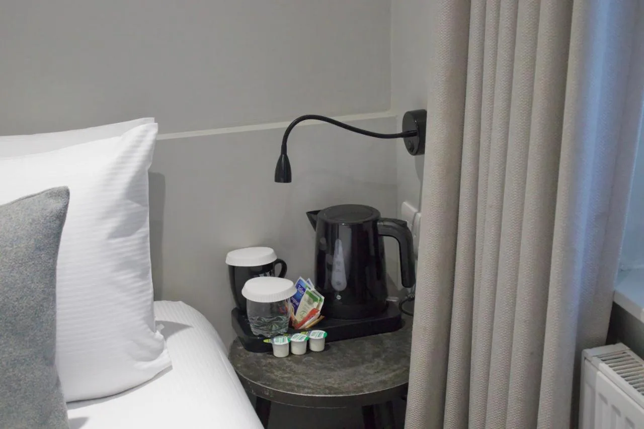 a coffee maker on a table next to a bed at Howard Winchester Hotel in London