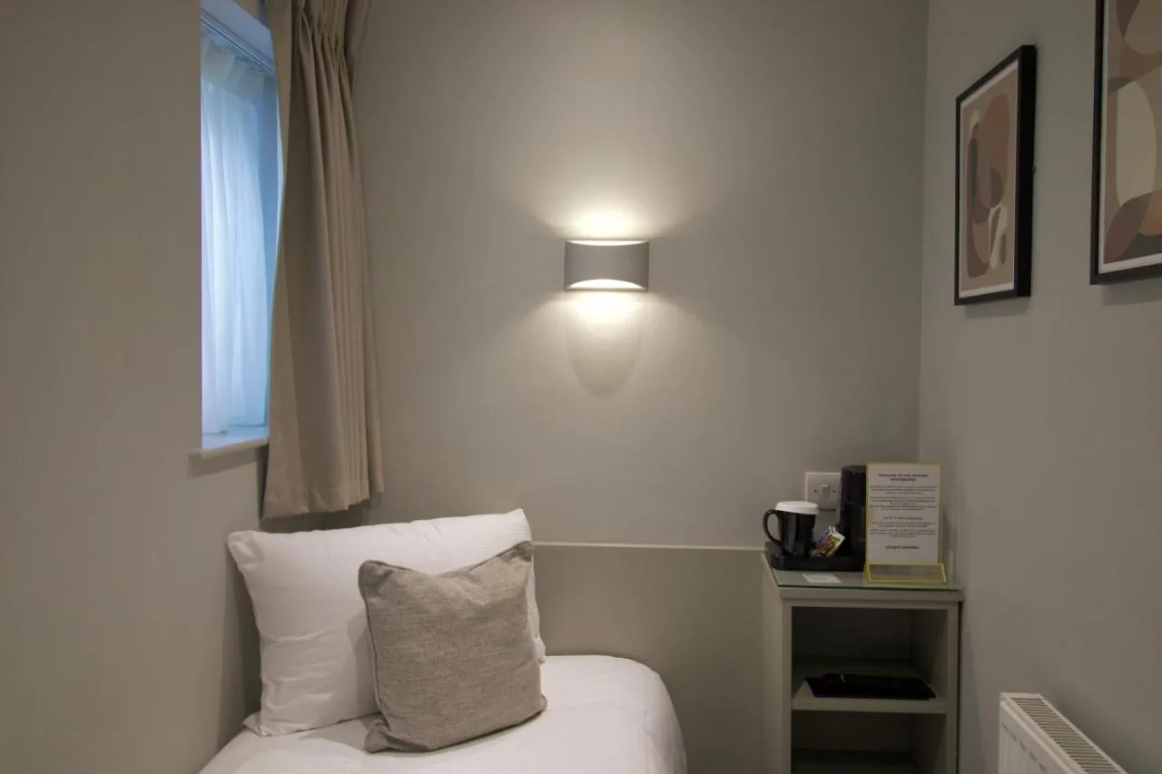 a room with a bed with a pillow and a light at Howard Winchester Hotel in London