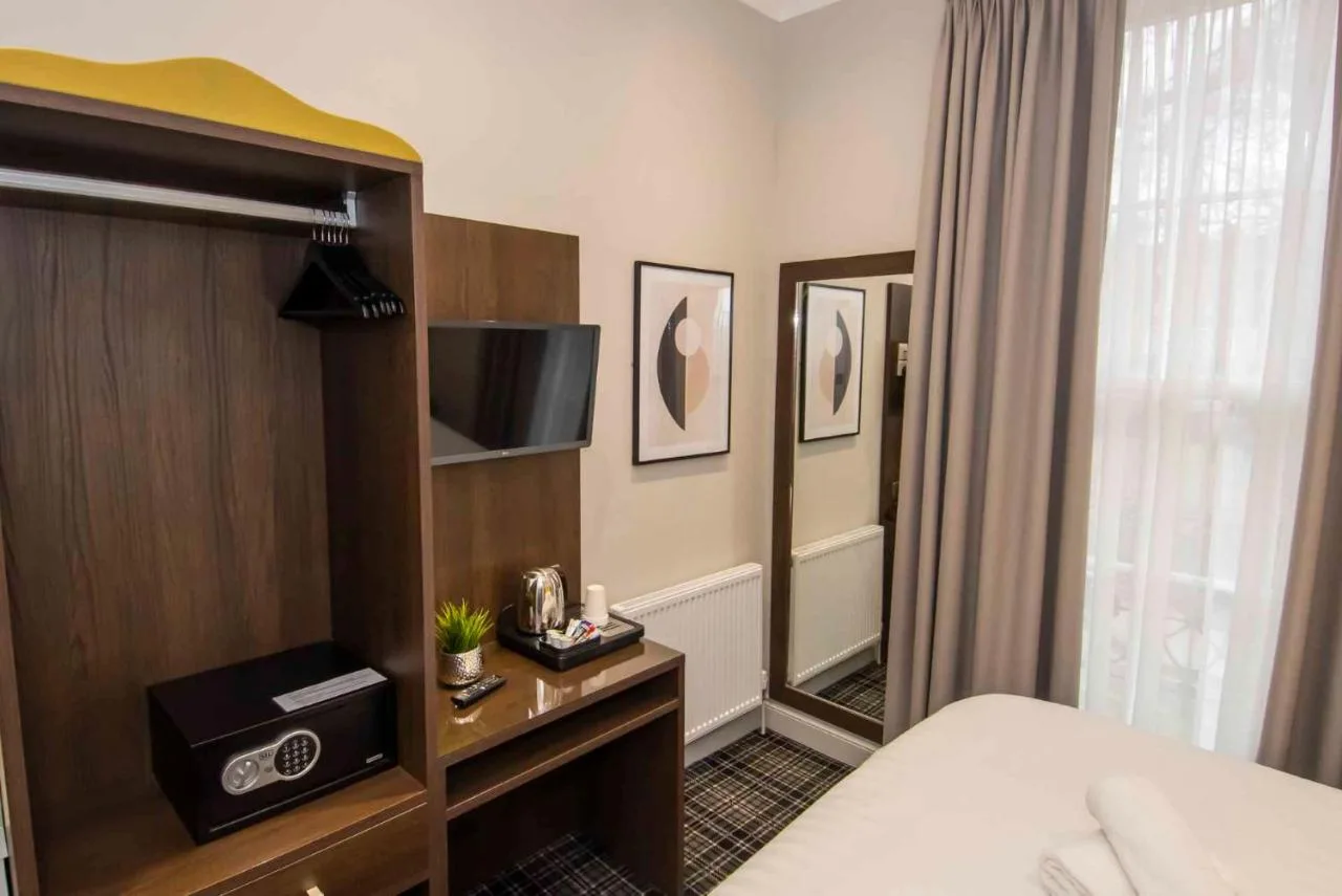 a hotel room with a bed and a television at Howard Winchester Hotel in London